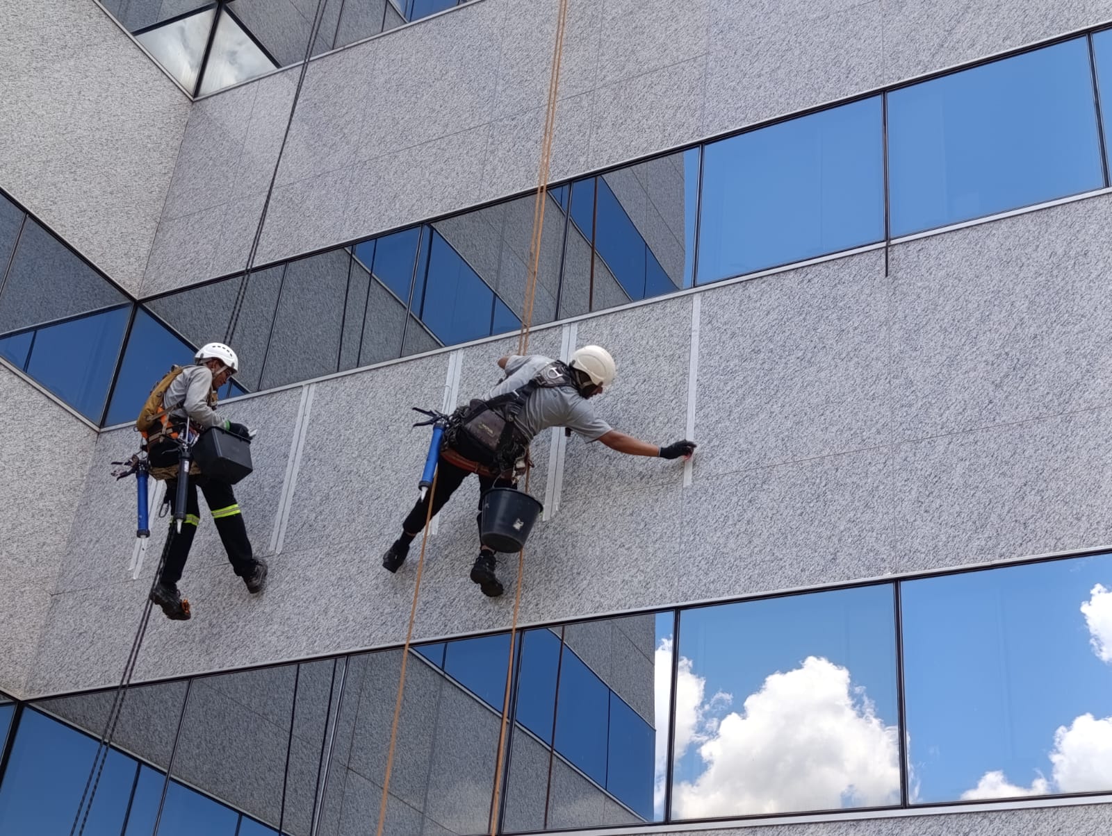 Equipe Cintilar em rapel executando manutenção em fachada predial